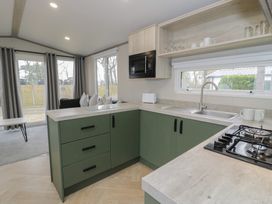 A kitchen with cabinets and appliances at Woodlands Gold (WO06) Ruthin