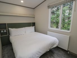 A bedroom with a bed and window at Woodlands Gold (WO06) in Ruthin