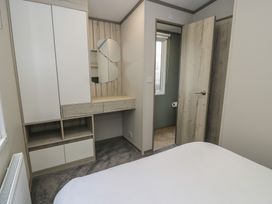 A bedroom with wardrobe and desk at Woodlands Gold (WO06) in Ruthin