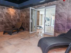 A lounge area with chairs and a sliding door at Woodlands Gold (WO06) in Ruthin