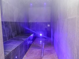 A steam room with benches and a water drain at Woodlands Gold (WO06) in Ruthin