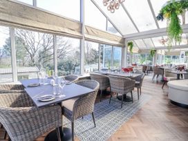 A dining room with tables and chairs at Woodlands Gold (WO06) in Ruthin