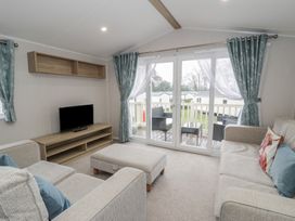 A living room with a sofa and television at Woodlands Platinum (WO29) in Ruthin