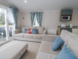 A living room with a sofa and a microwave at Woodlands Platinum (WO29) in Ruthin
