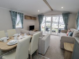 A living room with a sofa and dining table at Woodlands Platinum (WO29) Ruthin