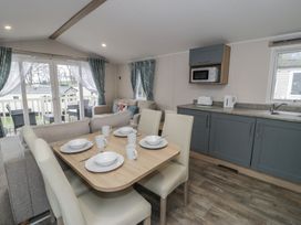 A kitchen with a dining table and chairs at Woodlands Platinum (WO29) Ruthin