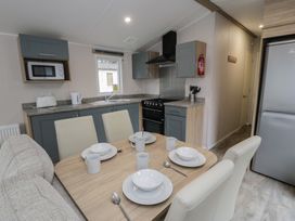 A kitchen with dining table and appliances at Woodlands Platinum (WO29) in Ruthin