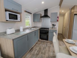 A kitchen with appliances and dining area at Woodlands Platinum (WO29) in Ruthin