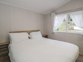A bedroom with a double bed and nightstands at Woodlands Platinum (WO29) in Ruthin