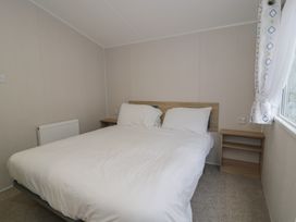 A bedroom with a bed and bedside table at Woodlands Platinum (WO29) in Ruthin