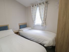 A bedroom with two beds and a window at Woodlands Platinum (WO29) in Ruthin