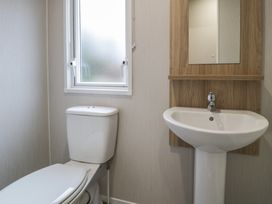 A bathroom with a toilet and sink at Woodlands Platinum (WO29) Ruthin