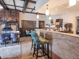 A bar area with stools and a fireplace at Woodlands Platinum (WO29) in Ruthin