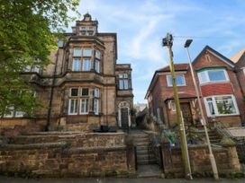Two attached residential buildings with stone and brick facades with stairs leading to the entrances at Coronation House in Scarborough