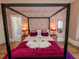 A bedroom with a four-poster bed and folded towels shaped like swans at Coronation House in Scarborough