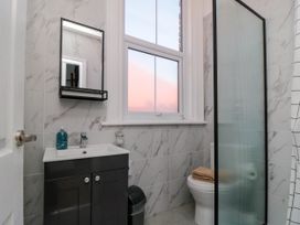 A bathroom with a sink cabinet mirror window toilet and shower at Coronation House in Scarborough