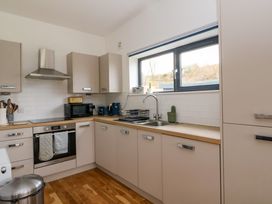 A kitchen with beige cabinets wooden countertops a stainless steel oven and hood a window above the sink at Dundarach in Aberfeldy