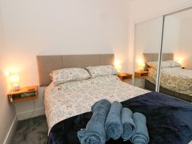 A bedroom with a bed with animal print bedding and rolled towels on top at Dundarach in Aberfeldy
