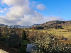 A rural landscape with hills and fields under a cloudy sky at Dundarach in Aberfeldy