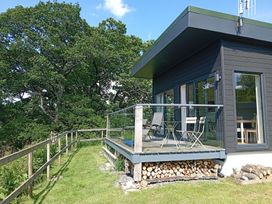 A deck with chairs and a table at Dundarach Aberfeldy