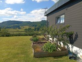 A garden with plants and a house at Dundarach in Aberfeldy