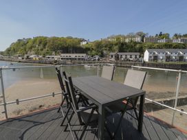 An outdoor dining area with a table and chairs overlooking the water at Seafarer's Haven in Porthmadog