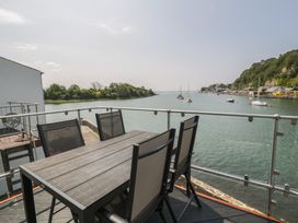 An outdoor seating area with a table and chairs overlooking the water at Seafarer's Haven in Porthmadog