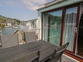 An outdoor area with a table and chairs overlooking the water at Seafarer's Haven in Porthmadog