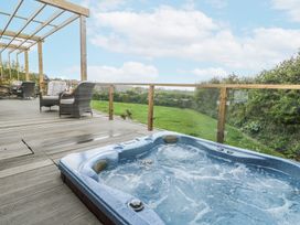 An outdoor space with a hot tub and seating area at Petroc in Portreath
