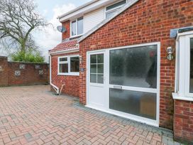 A brick house exterior with frosted glass door and windows and a paved driveway at 14 Birchwood Road in Woolaston