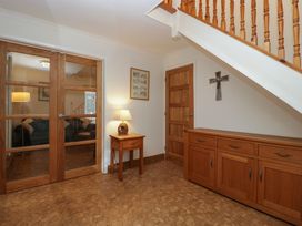 An entryway with wooden furniture and a staircase at 14 Birchwood Road in Woolaston