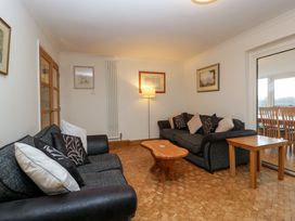 A living room with two sofas a wooden coffee table a lamp and framed pictures on the wall at 14 Birchwood Road in Woolaston