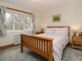 A bedroom with a wooden bed and two bedside tables with lamps at 14 Birchwood Road in Woolaston