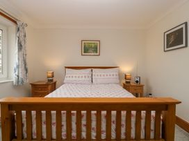 A bedroom with a wooden bed and matching bedside tables with lamps at 14 Birchwood Road in Woolaston