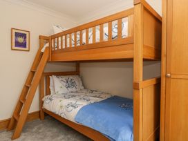 A bedroom with wooden bunk beds and a framed picture on the wall at 14 Birchwood Road in Woolaston