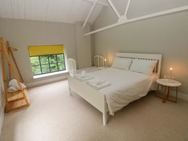 A bedroom with a bed and window at The Old Creamery in Ffairfach