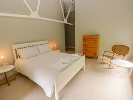 A bedroom with a bed and wooden furniture at The Old Creamery in Ffairfach
