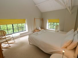 A bedroom with a bed and window at The Old Creamery in Ffairfach