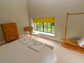 A bedroom with a bed and wooden furniture at The Old Creamery in Ffairfach