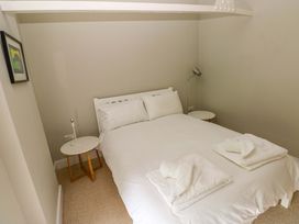 A bedroom with a bed, bedside table, and lamp at The Old Creamery in Ffairfach
