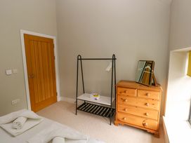 A bedroom with a clothes rack and chest of drawers at The Old Creamery in Ffairfach