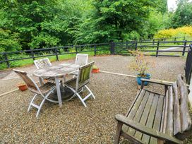 An outdoor area with a table and chairs beside a gravel surface at The Old Creamery Ffairfach