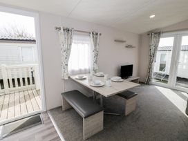 A dining area with a table and chairs at Gold Caravan (316) Talybont
