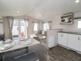 A living room with a sofa and dining table at Gold Caravan (316) Talybont