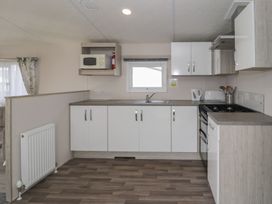 A kitchen with cabinets and appliances at Gold Caravan (316) Talybont