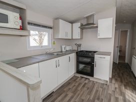 A kitchen with a stove and cabinets at Gold Caravan (316) Talybont