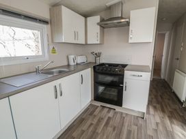 A kitchen with cabinets and appliances at Gold Caravan (316) Talybont