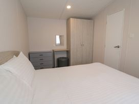 A bedroom with a bed and wardrobe at Gold Caravan (316) Talybont