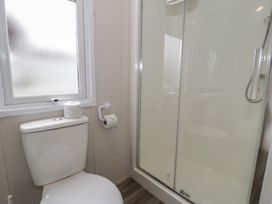 A bathroom with a toilet and a shower at Gold Caravan (316) Talybont