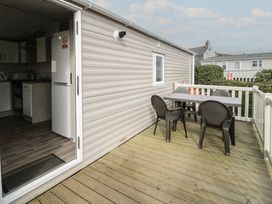An outdoor deck with a table and chairs at Gold Caravan (316) Talybont
